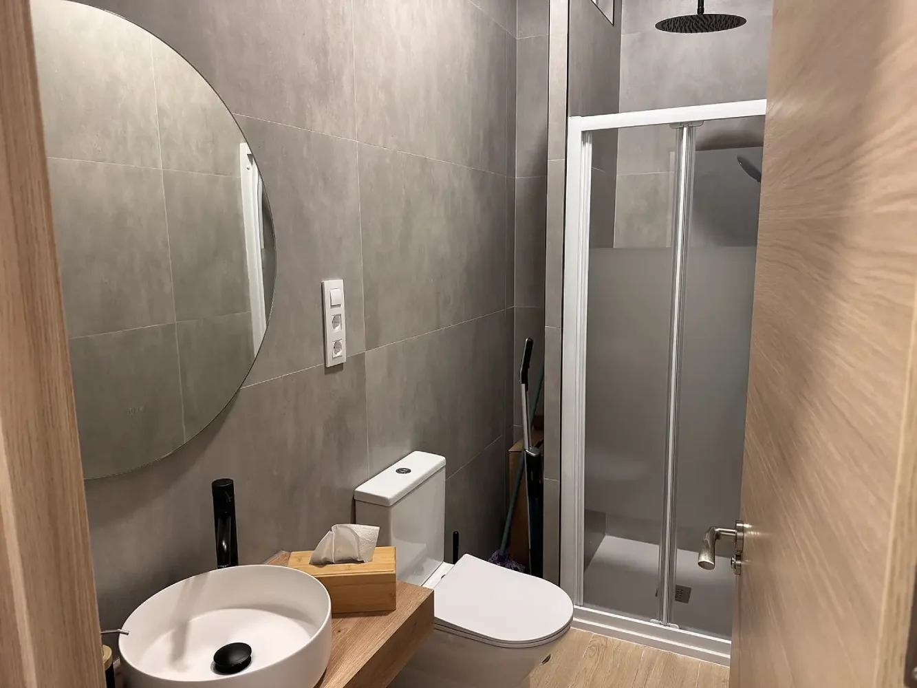 Baño moderno con ducha y azulejos grises en el centro de entrenamiento